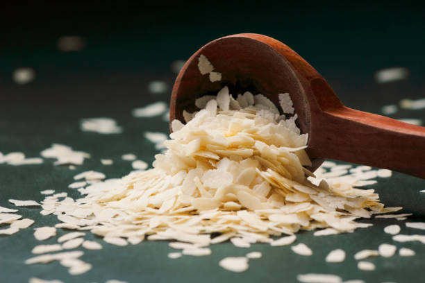Raw Flattened Rice or Thick or thin Rice Flakes for Namkeen Chivda snacks or Aloo Poha for Indian Breakfast, served in a spoon